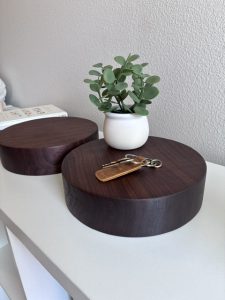 Custom dark walnut speaker risers used beneath a plant and keys